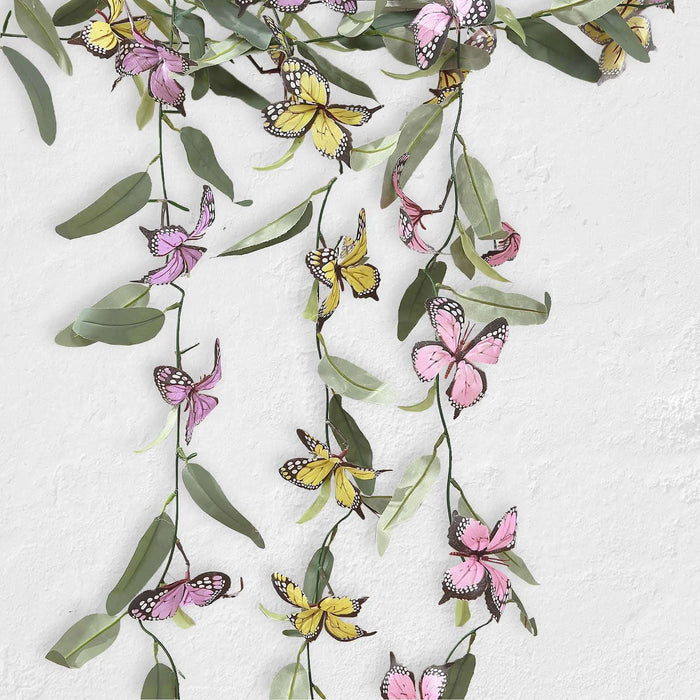 Colorful butterfly and leaf garland decoration on a white background.
