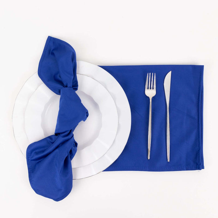 Blue napkin on white plate with cutlery on a placemat