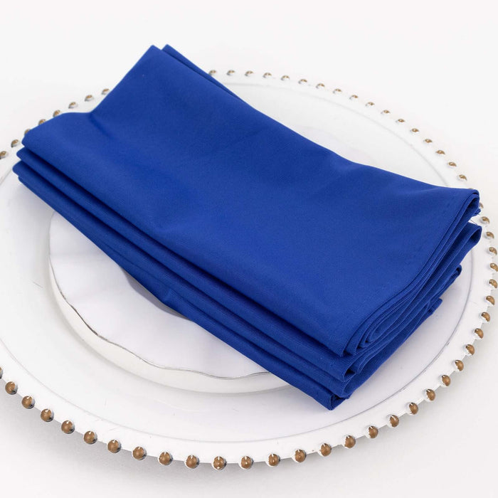 Blue napkins neatly folded on a decorative plate.