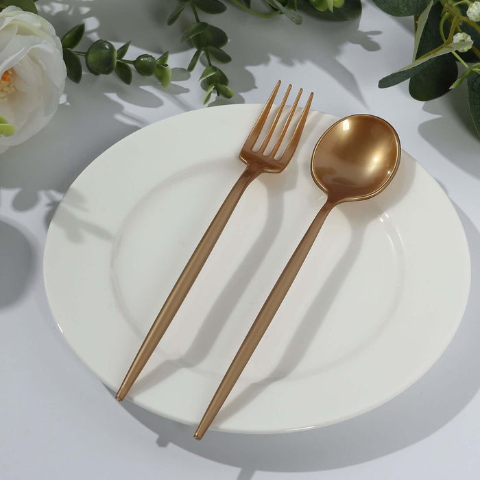 Gold fork and spoon on a white plate, surrounded by greenery.