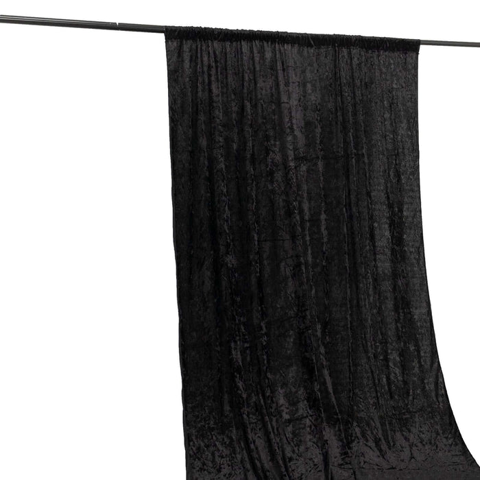 Black velvet backdrop fabric hanging on a support rod.