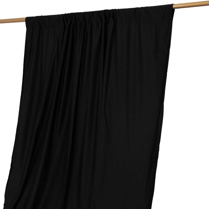 Black curtain draped on a wooden rod against a white background
