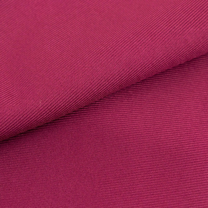 Close-up of textured fuchsia fabric showcasing its rich color and pattern.