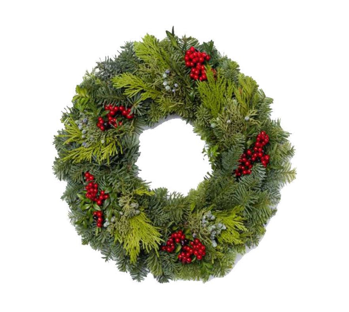 The Candle Ring - Canella from Available for Pick-up & Delivery is a festive holiday wreath of pine and fir branches with bright red berries, arranged in a circular shape to bring seasonal magic against a white background.