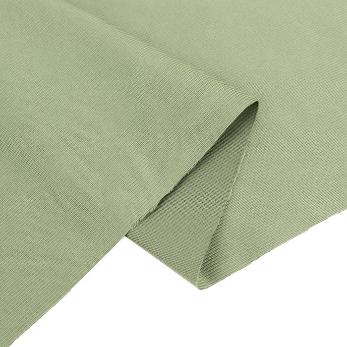 Green ribbed fabric close-up showing texture and detail.