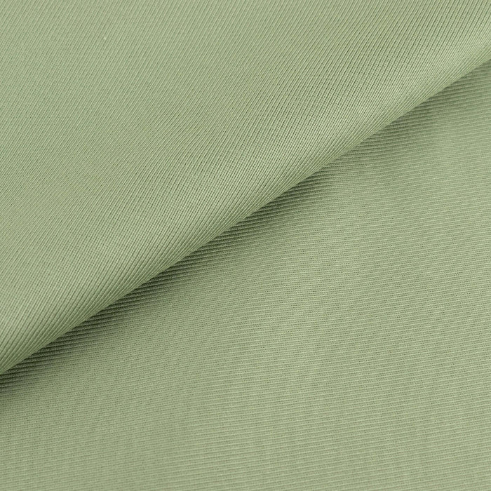 Textured green fabric close-up showing soft, ribbed surface details.