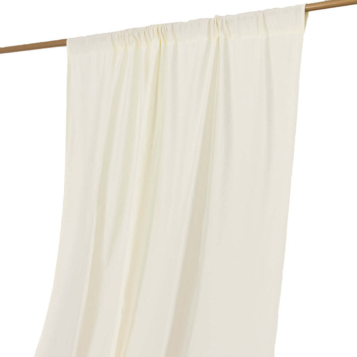 Cream curtain panel draped on a wooden rod