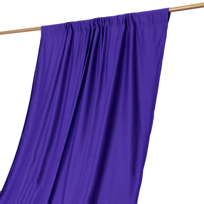 Purple fabric draped on a wooden rod, showcasing smooth texture and vibrant color.