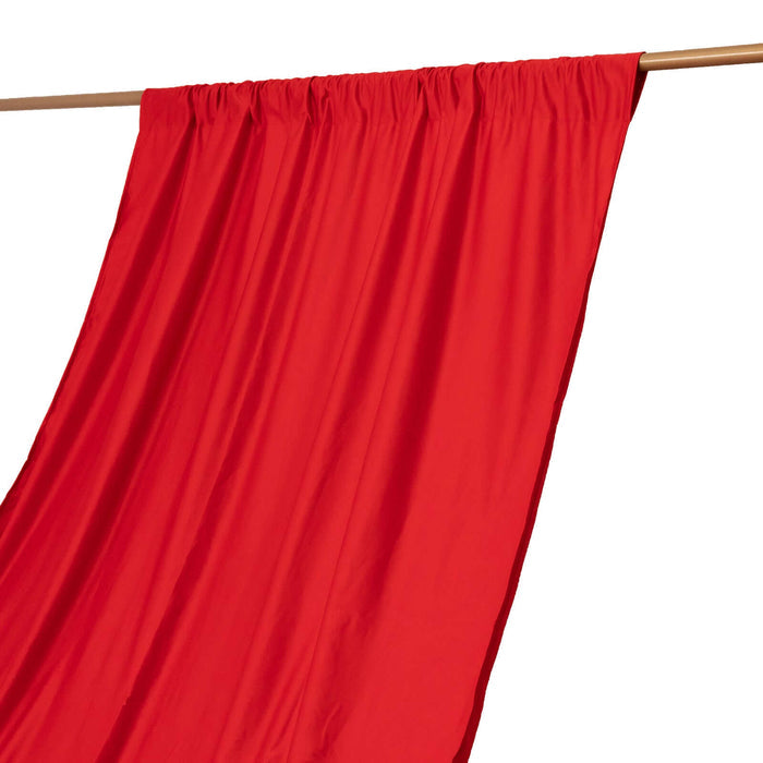 Red fabric draped on a wooden rod against a white background