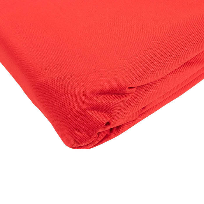 Folded vibrant red fabric on a plain background