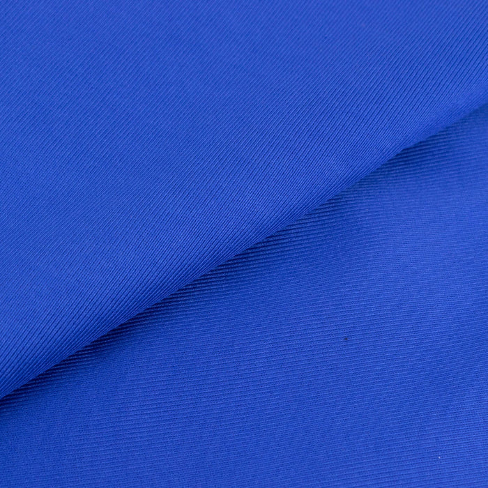 Blue textured fabric close-up showing a smooth surface and rich color.