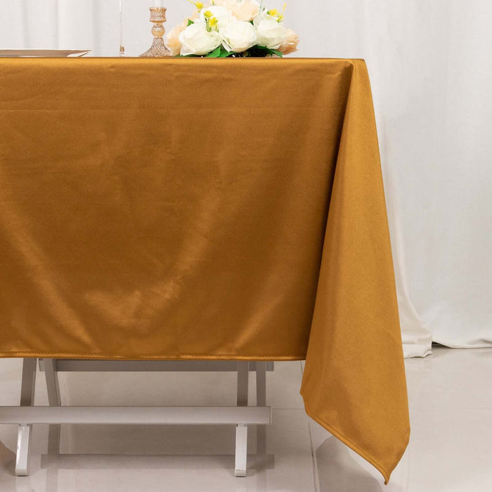 Gold tablecloth draped elegantly over a table with floral centerpiece.