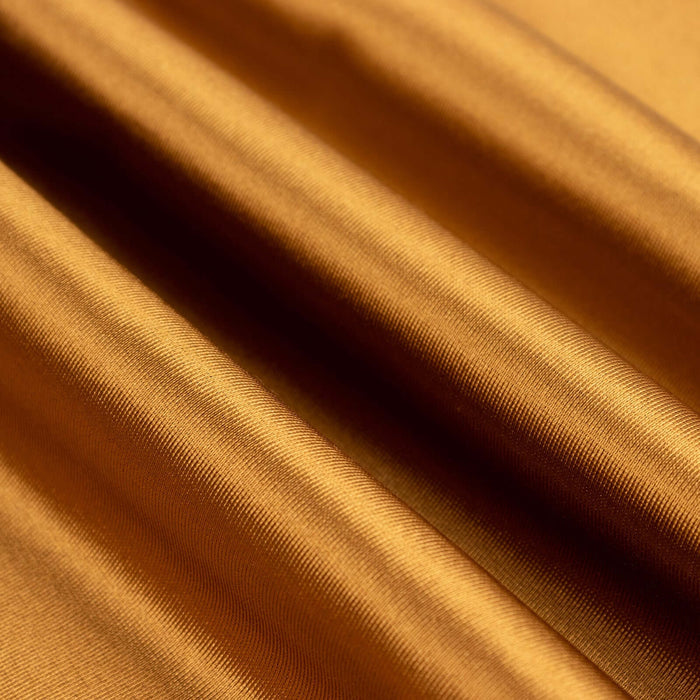 Close-up of luxurious golden fabric with smooth texture.