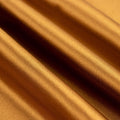 Close-up of luxurious golden fabric with smooth texture.